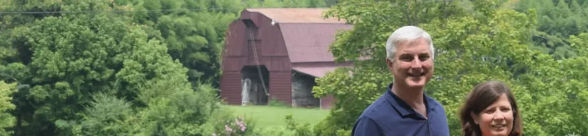 Stephen and Maria Seibert in a pasture in front of a red barn near Hartselle, Alabama