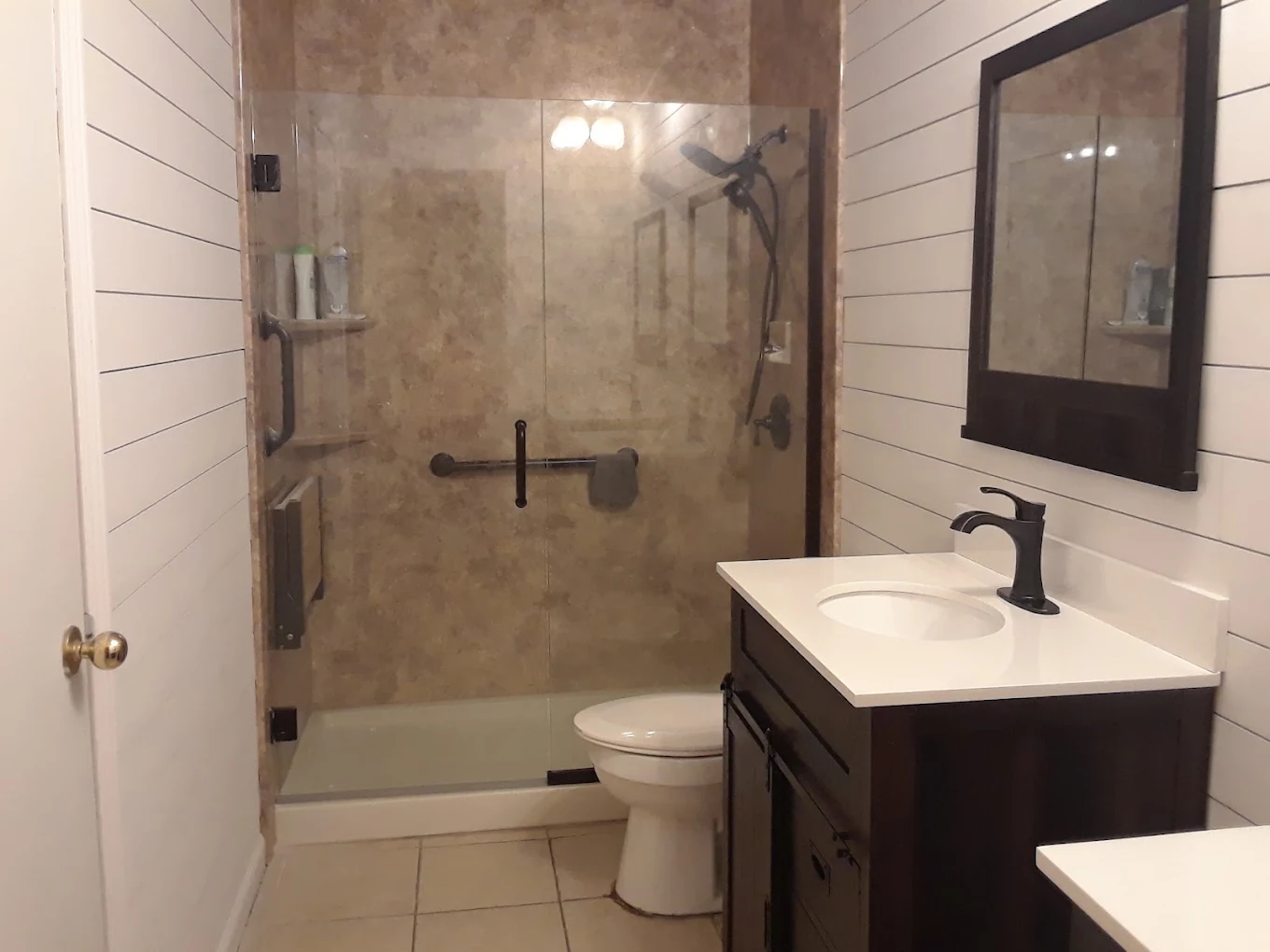 Bathroom finished by Stephen Seibert Plumbing with a tiled walk-in shower, new toilet and vanity