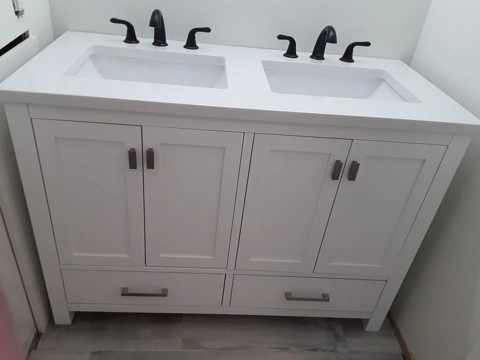 New white double-sink vanity with two oil-rubbed bronze faucets installed